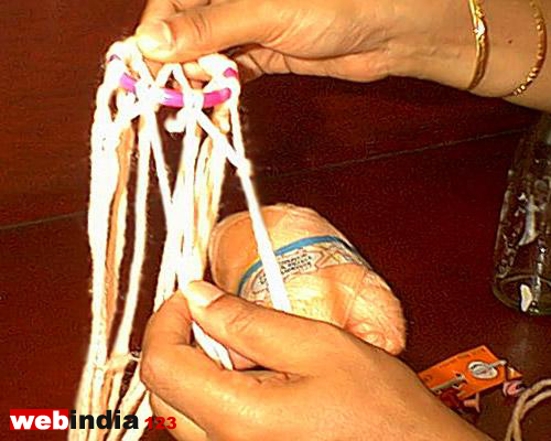 Nine triangular knots with nine pairs of wool thread hanging from it
