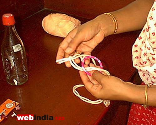 Tying a knot on the bangle with the two stranded thread