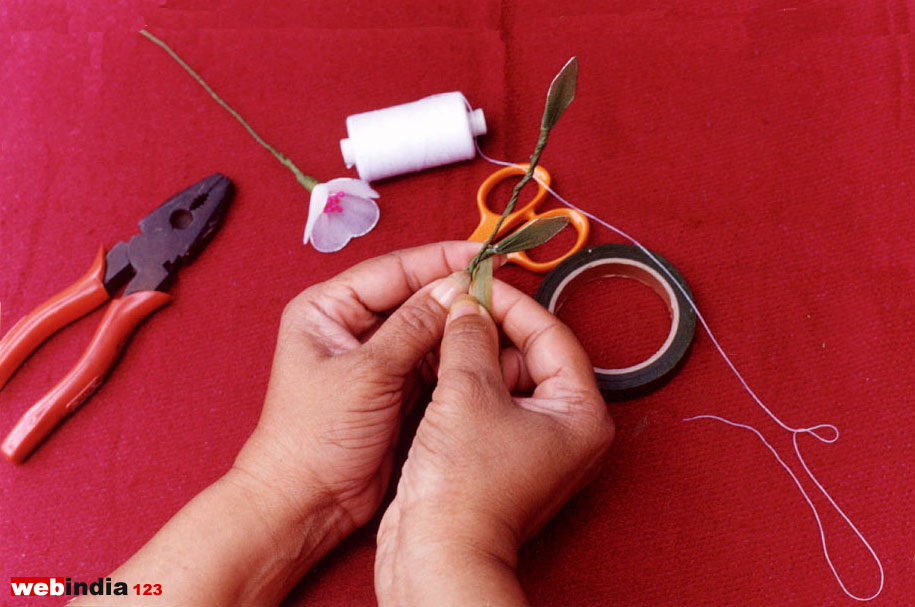 Fixing the leaves to the stalk by winding with the green tape