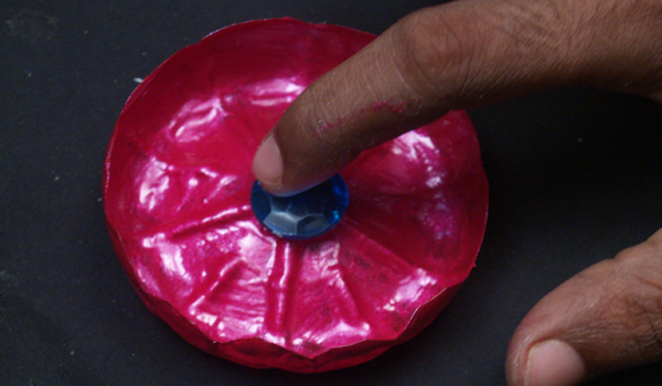 large colored stone to the center of the plastic bottle flower